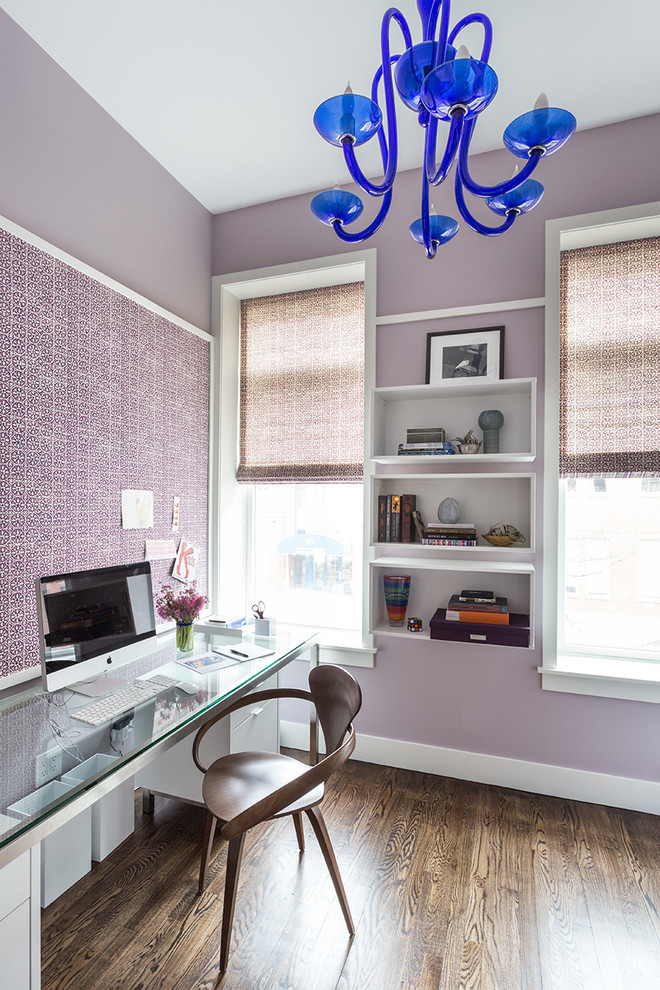 Ejemplo de despacho actual con paredes púrpuras, suelo de madera en tonos medios y escritorio independiente