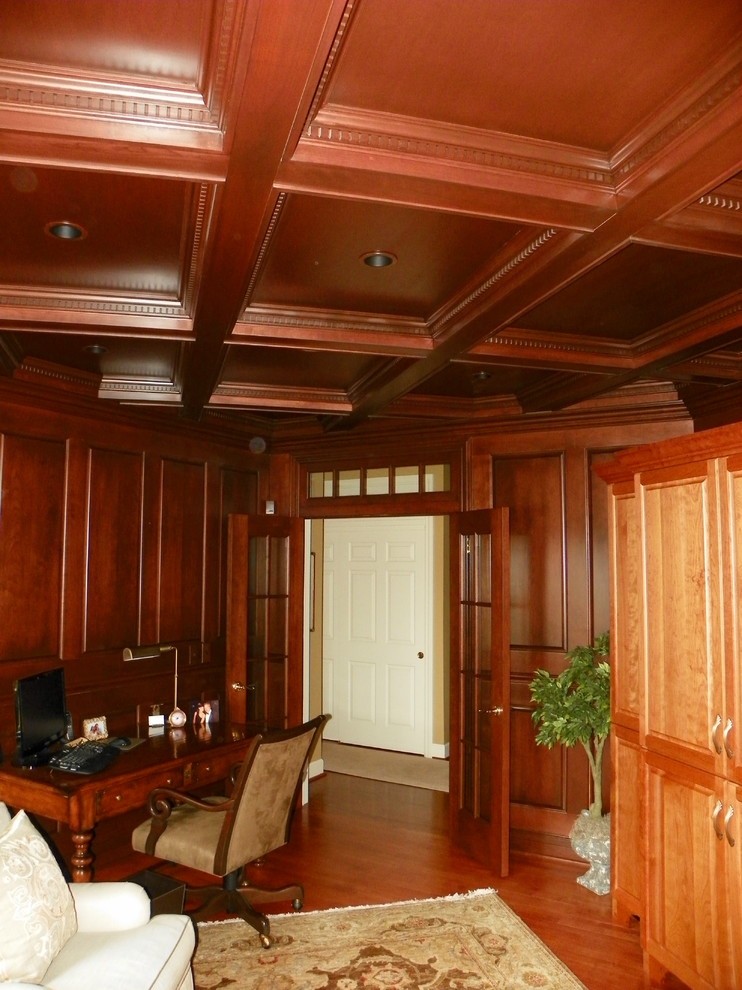 Example of a large classic freestanding desk medium tone wood floor study room design in New York with brown walls and no fireplace
