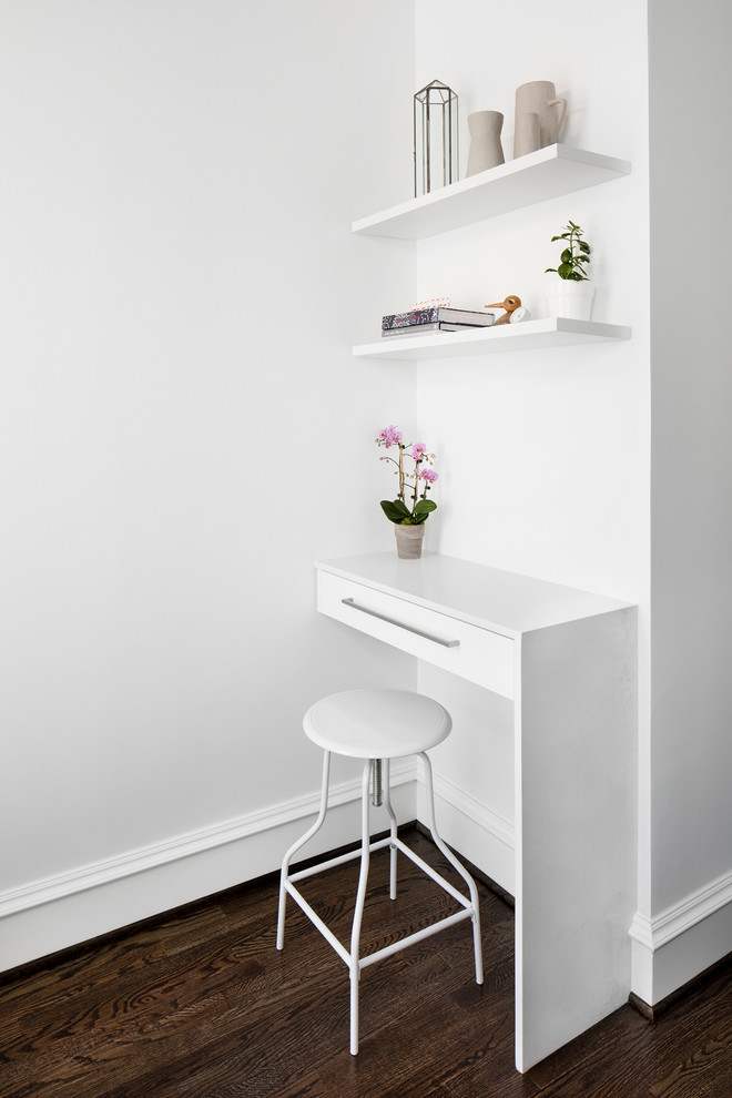Immagine di un piccolo ufficio moderno con parquet scuro, pareti bianche e scrivania incassata