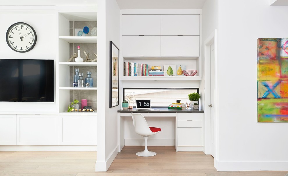 Diseño de despacho contemporáneo pequeño sin chimenea con paredes blancas, suelo de madera clara y escritorio empotrado