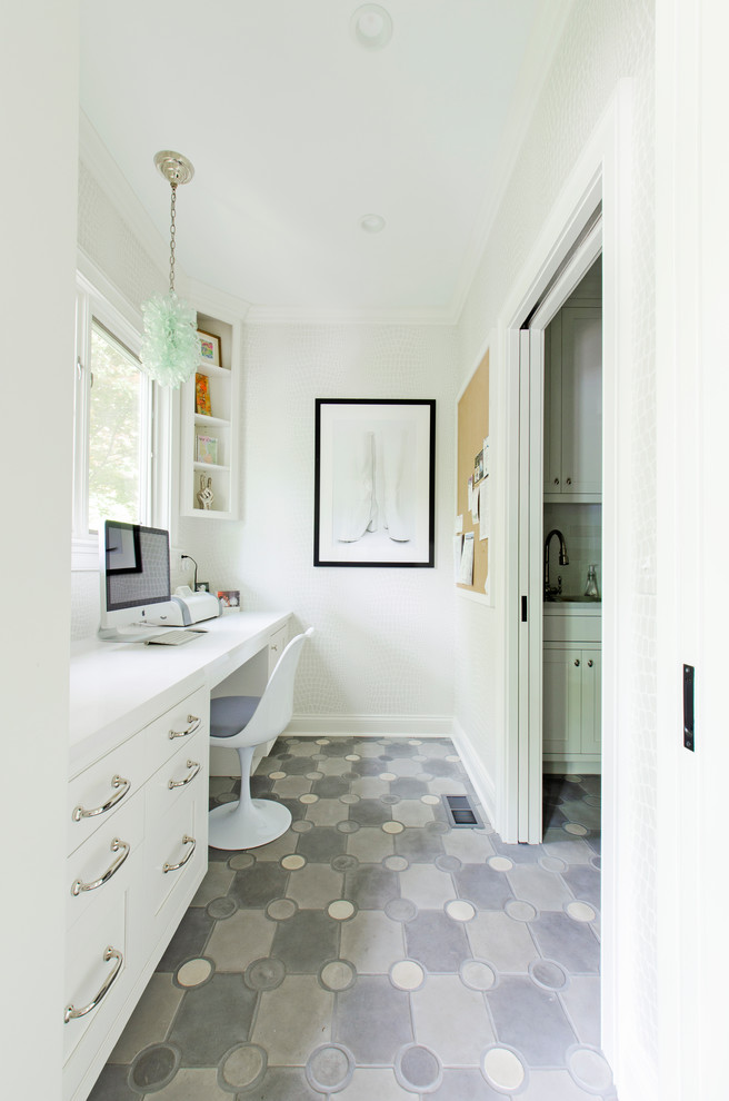 Modelo de despacho clásico renovado con paredes blancas, escritorio empotrado y suelo gris