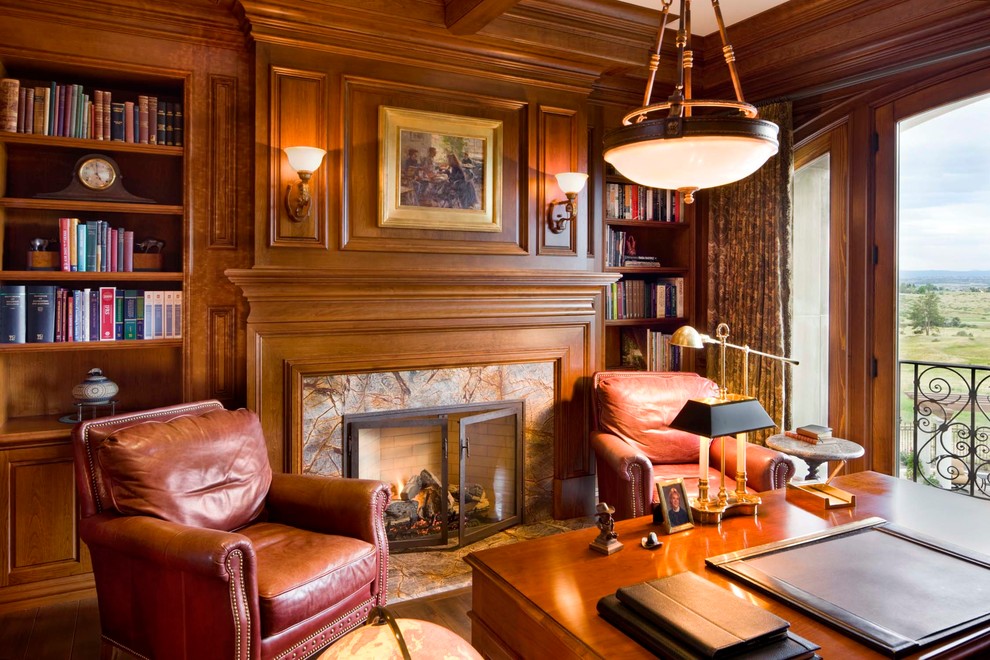 デンバーにある中くらいな地中海スタイルのおしゃれな書斎 (茶色い壁、無垢フローリング、標準型暖炉、石材の暖炉まわり、自立型机) の写真