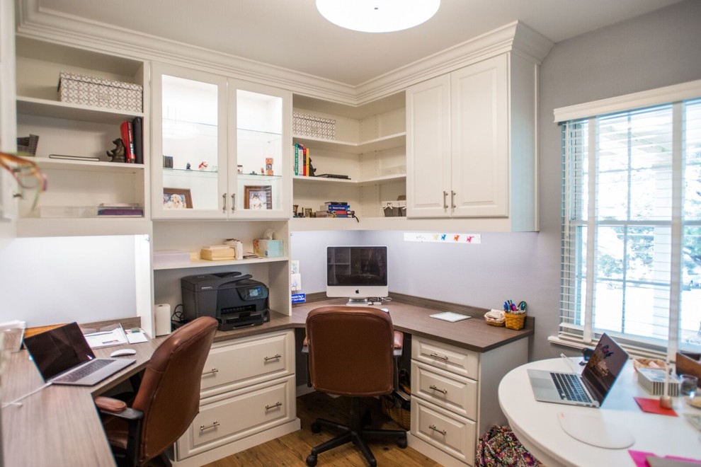 Ejemplo de despacho tradicional renovado de tamaño medio sin chimenea con paredes grises, suelo de madera clara, escritorio empotrado y suelo marrón