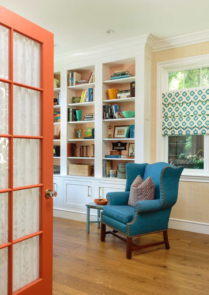 Foto på ett mellanstort lantligt hemmabibliotek, med ljust trägolv, brunt golv och beige väggar