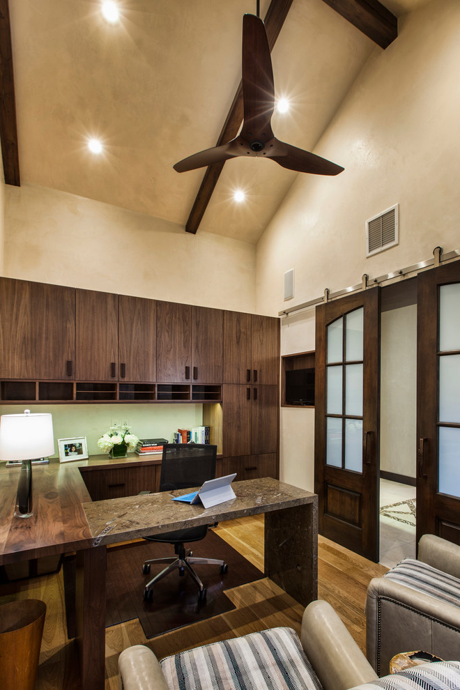 Aménagement d'un bureau de taille moyenne avec un mur beige, parquet clair, un bureau intégré et un sol marron.