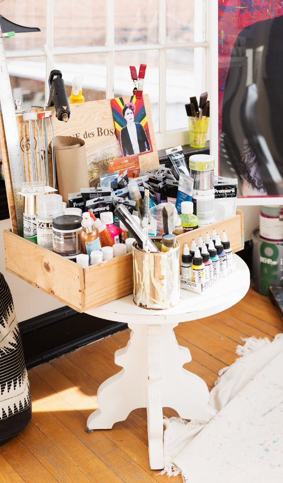 Modelo de estudio bohemio pequeño con paredes blancas, suelo de madera clara, escritorio independiente y suelo marrón
