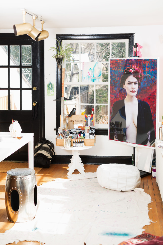 Immagine di un piccolo atelier bohémian con pareti bianche, parquet chiaro, scrivania autoportante e pavimento marrone