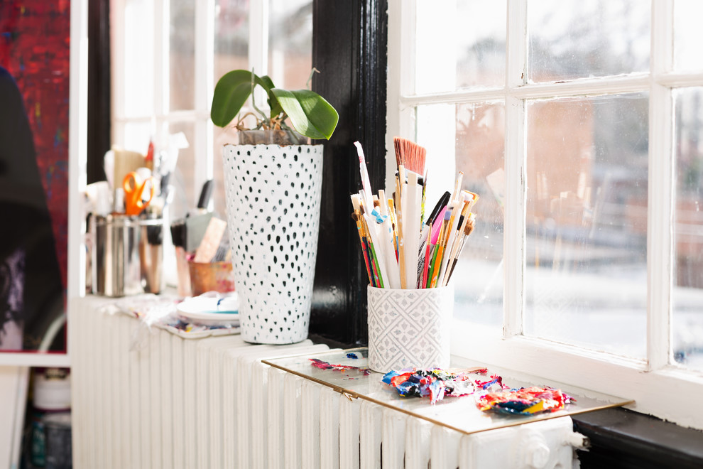 Immagine di un piccolo atelier eclettico con pareti bianche, parquet chiaro, scrivania autoportante e pavimento marrone