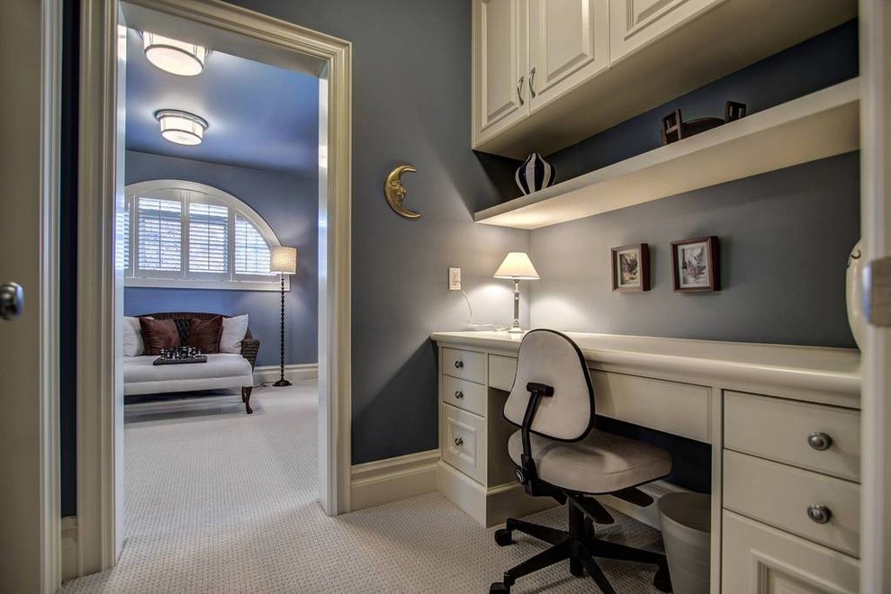 Kleines Uriges Arbeitszimmer mit blauer Wandfarbe, Teppichboden, Einbau-Schreibtisch und beigem Boden in New York