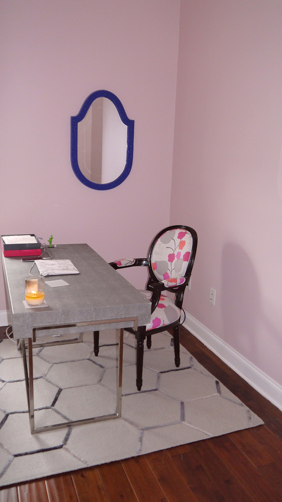 This is an example of a medium sized modern study in DC Metro with pink walls, medium hardwood flooring and a freestanding desk.