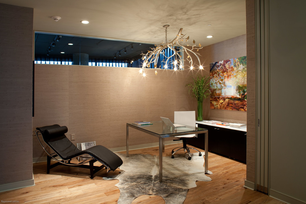 Exempel på ett modernt arbetsrum, med bruna väggar, ljust trägolv och ett fristående skrivbord