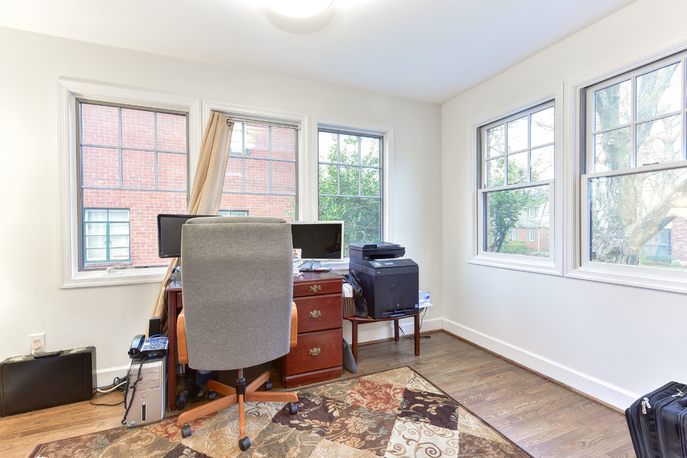 Mittelgroßes Klassisches Arbeitszimmer mit beiger Wandfarbe und freistehendem Schreibtisch