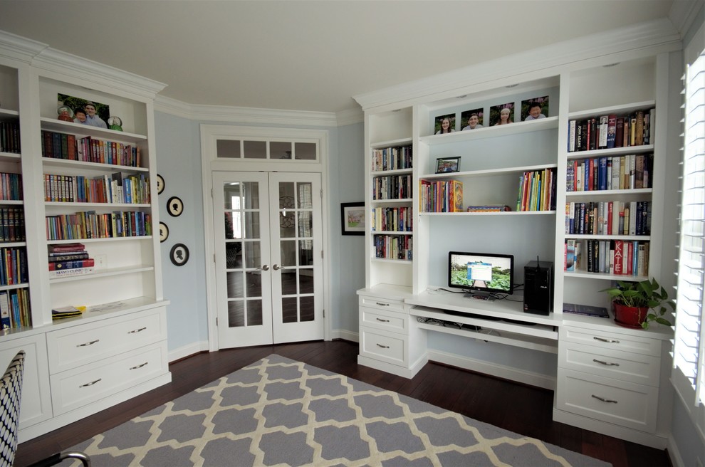 Design ideas for a large classic study in DC Metro with blue walls, medium hardwood flooring, no fireplace, a built-in desk and brown floors.