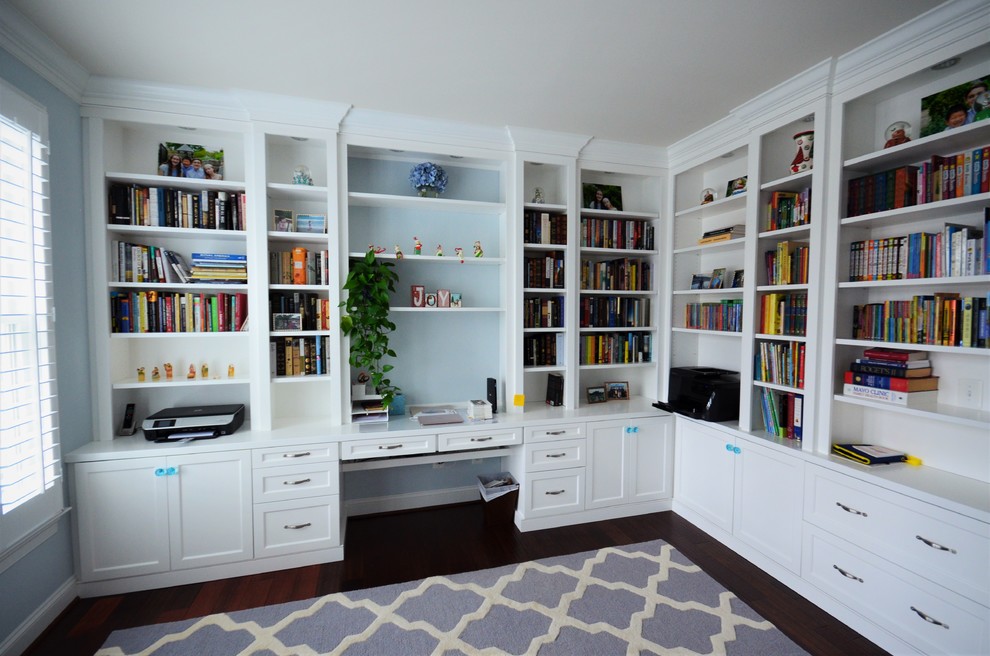 Idee per un grande ufficio classico con pareti blu, pavimento in legno massello medio, nessun camino, scrivania incassata e pavimento marrone
