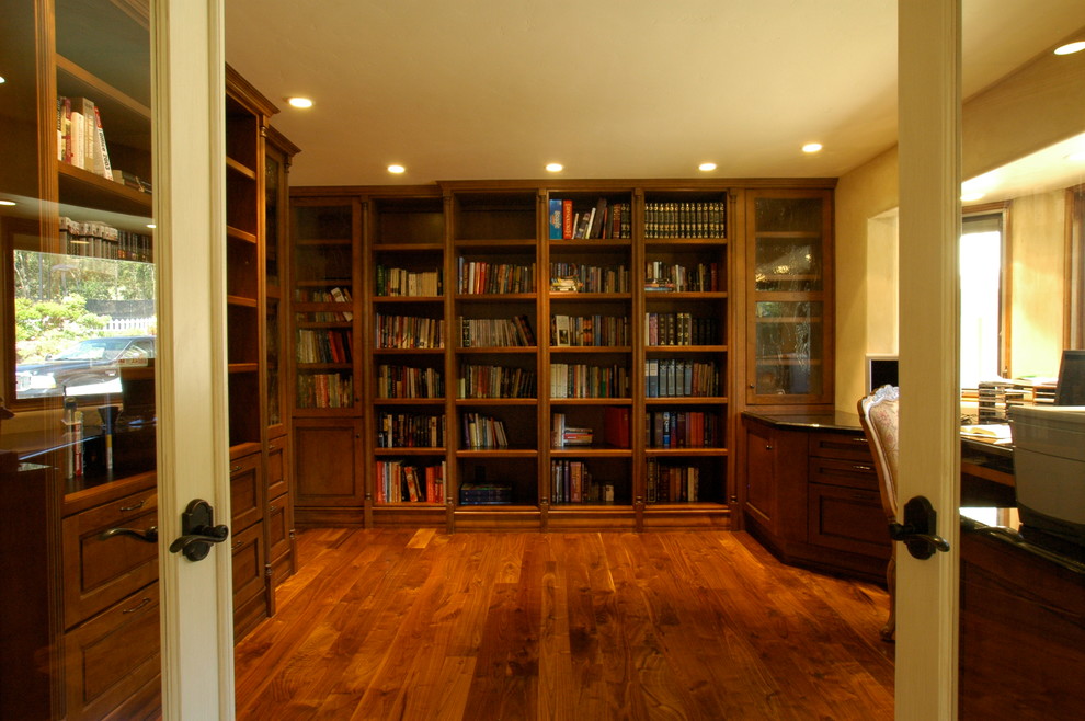Immagine di uno studio classico con pavimento in legno massello medio e scrivania incassata