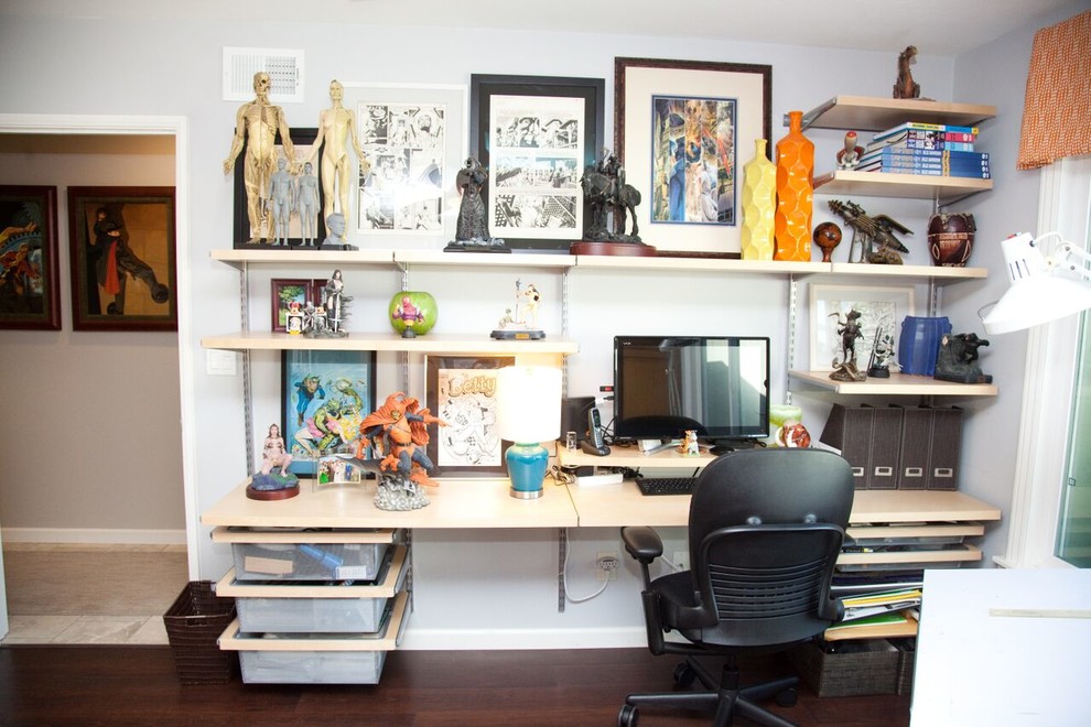 Cette image montre un bureau design de taille moyenne et de type studio avec un mur gris, parquet foncé, aucune cheminée et un bureau intégré.
