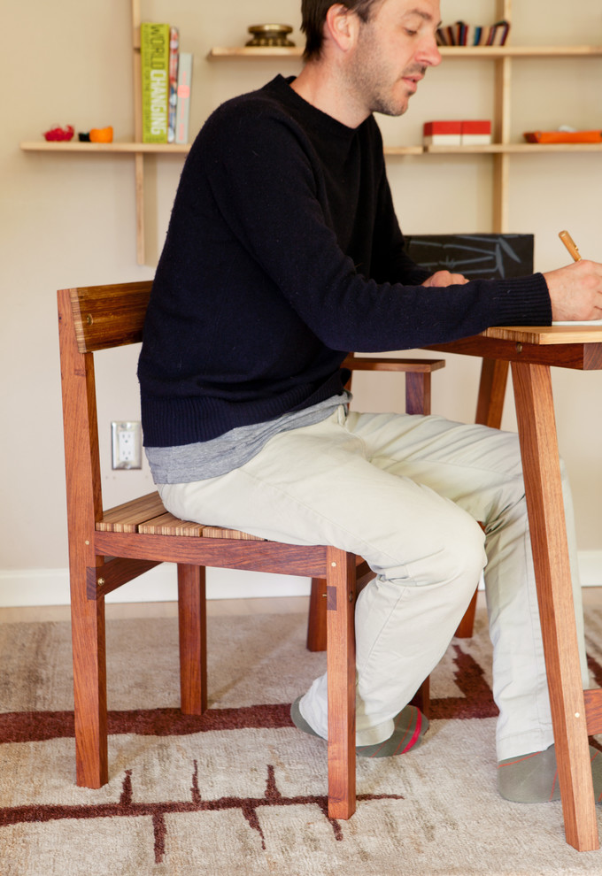 Imagen de estudio actual pequeño con paredes beige, suelo de madera clara y escritorio independiente