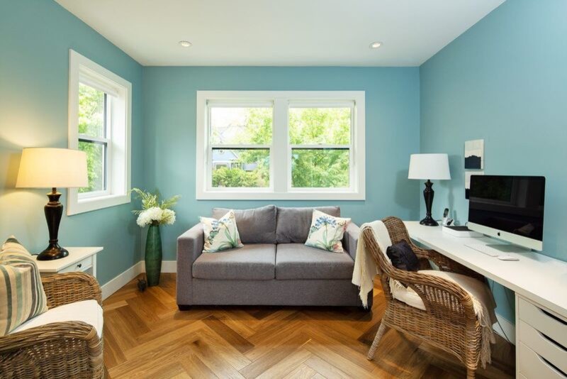 Ejemplo de despacho clásico de tamaño medio sin chimenea con paredes azules, suelo vinílico, escritorio independiente y suelo marrón