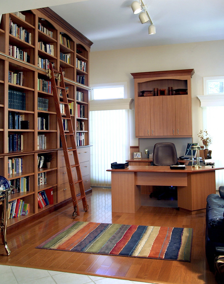 Idee per uno studio minimal con pareti beige, pavimento in legno massello medio e scrivania autoportante