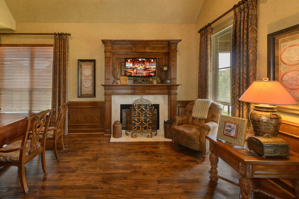 Study room - large mediterranean freestanding desk medium tone wood floor study room idea in Dallas with beige walls, a standard fireplace and a tile fireplace