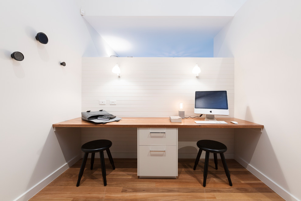 Inspiration pour un bureau design avec un mur blanc, parquet clair, un bureau intégré et aucune cheminée.