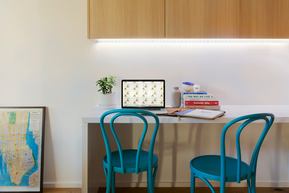Example of a small danish built-in desk light wood floor study room design in Sydney with white walls and no fireplace