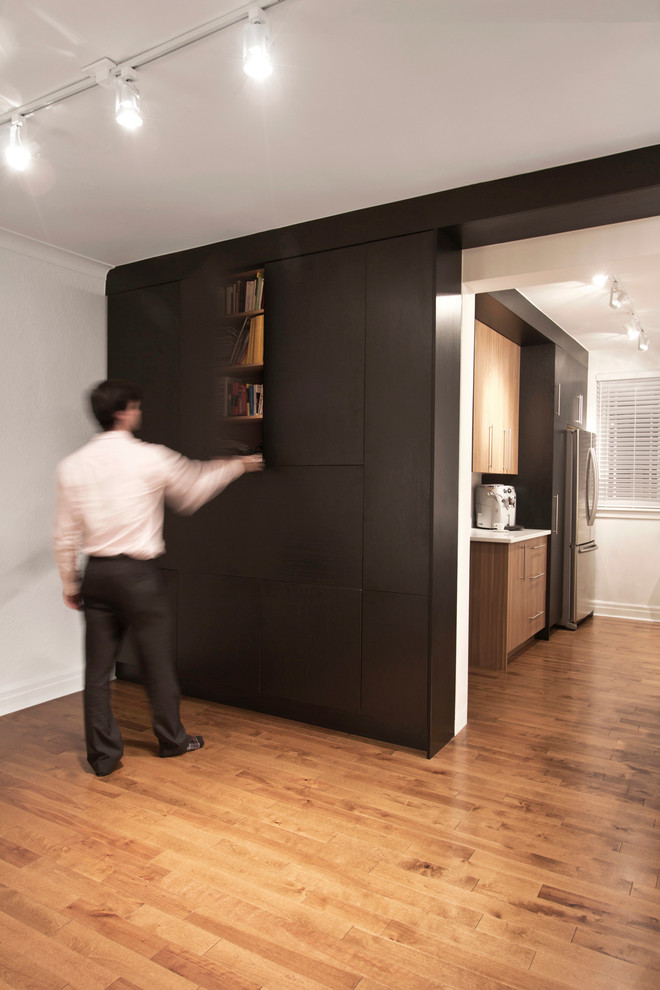 Inspiration för små moderna hemmastudior, med svarta väggar, mellanmörkt trägolv och ett inbyggt skrivbord