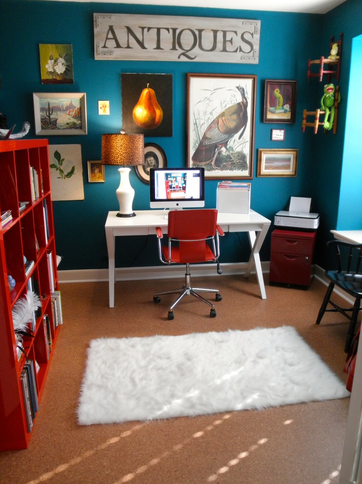 Ejemplo de despacho ecléctico con paredes azules y escritorio independiente