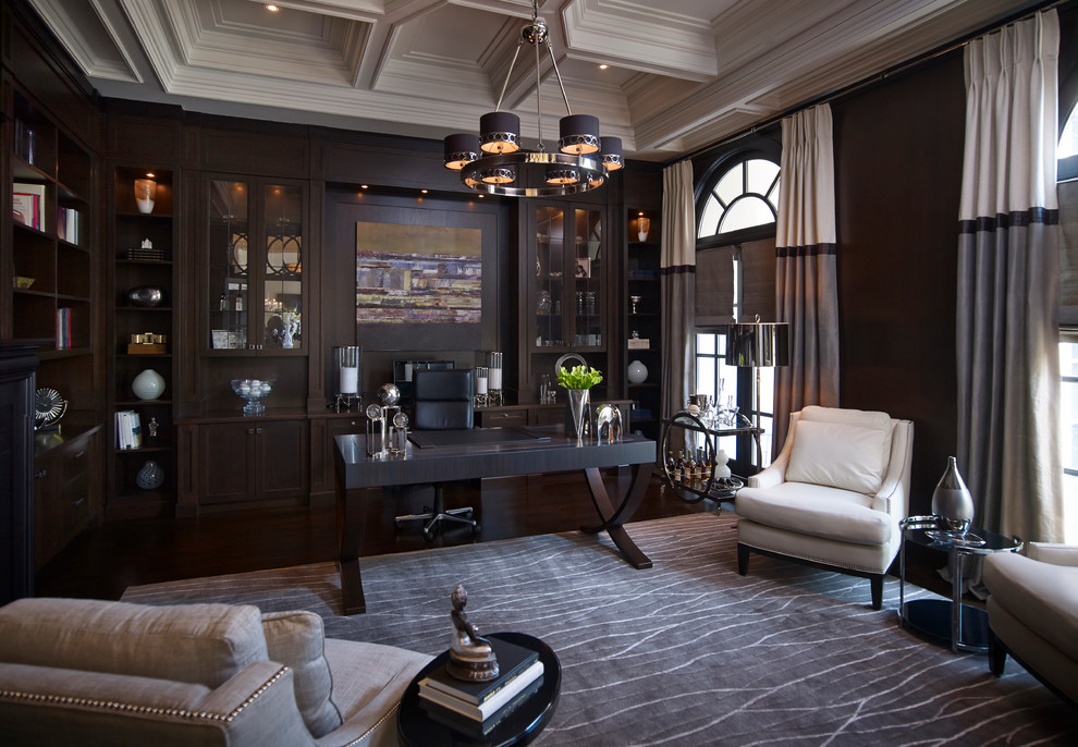This is an example of a large traditional study in Toronto with dark hardwood flooring, a freestanding desk and brown walls.