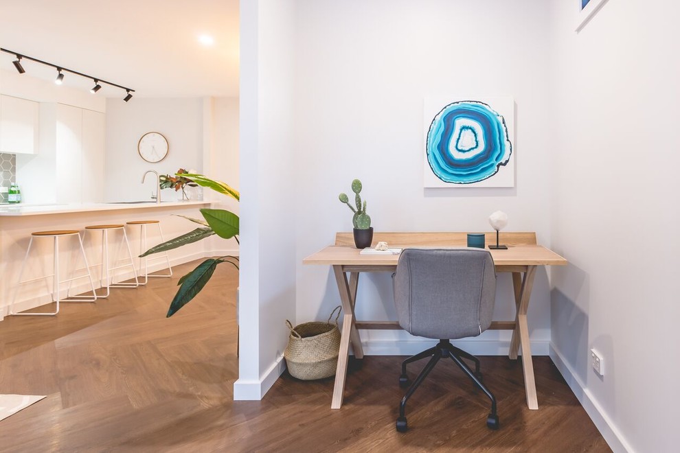 Cette image montre un petit bureau design avec un mur gris, un sol en vinyl, un bureau indépendant et un sol marron.