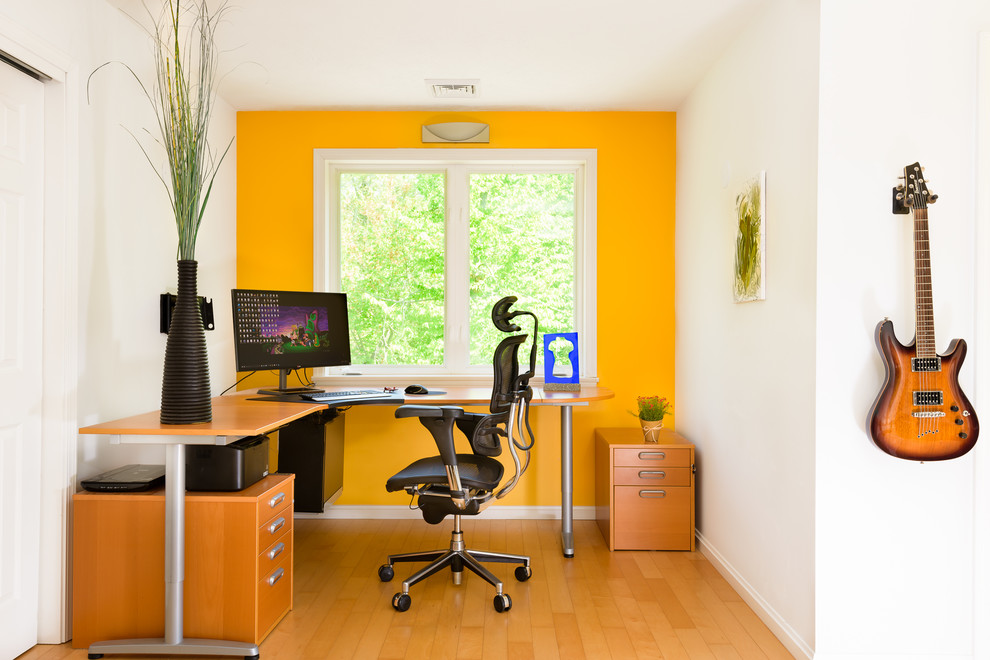 На фото: кабинет в современном стиле с оранжевыми стенами, паркетным полом среднего тона, отдельно стоящим рабочим столом и коричневым полом