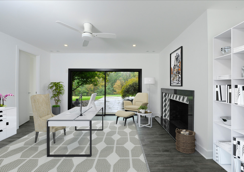 Example of a large trendy freestanding desk dark wood floor and gray floor home office design in New York with white walls, a standard fireplace and a tile fireplace