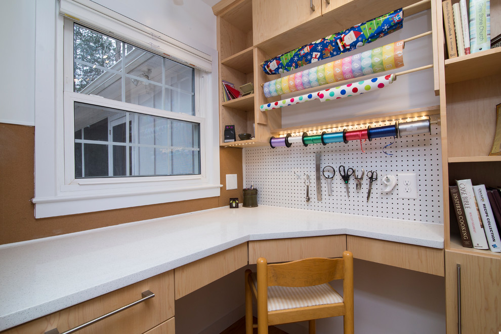 Diseño de sala de manualidades actual pequeña con paredes blancas, suelo de madera en tonos medios, escritorio empotrado y suelo naranja
