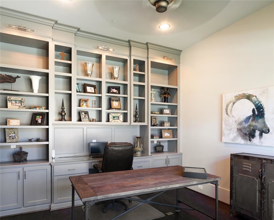 Large trendy built-in desk dark wood floor and brown floor study room photo in Houston with gray walls
