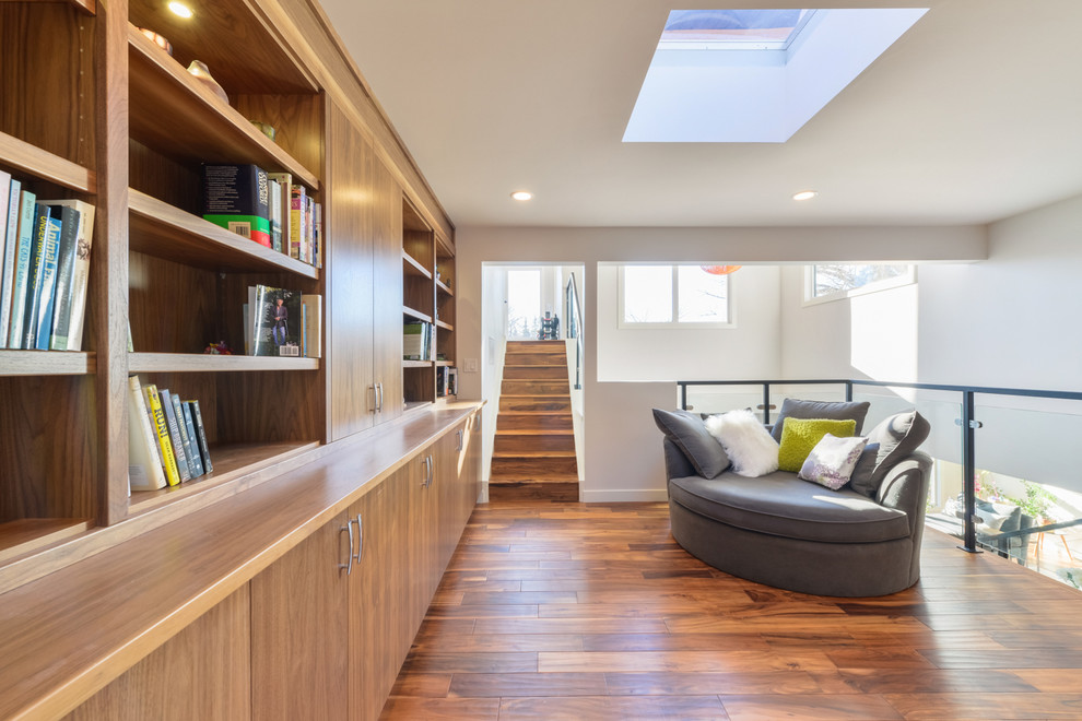 Mittelgroßes Modernes Lesezimmer ohne Kamin mit weißer Wandfarbe, braunem Holzboden und braunem Boden in Orange County