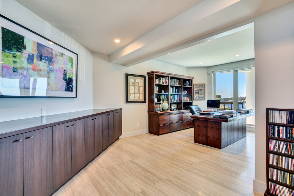 Diseño de despacho actual grande sin chimenea con paredes marrones, suelo de madera clara, escritorio independiente y suelo beige