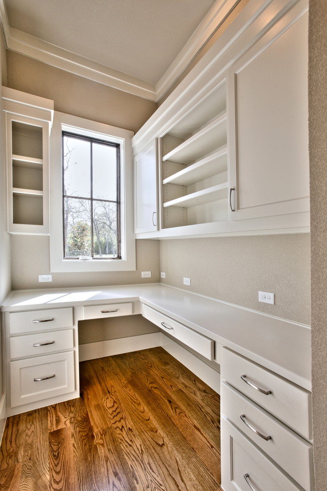 Cette image montre un bureau design de taille moyenne avec un mur beige, un sol en bois brun, aucune cheminée et un bureau intégré.