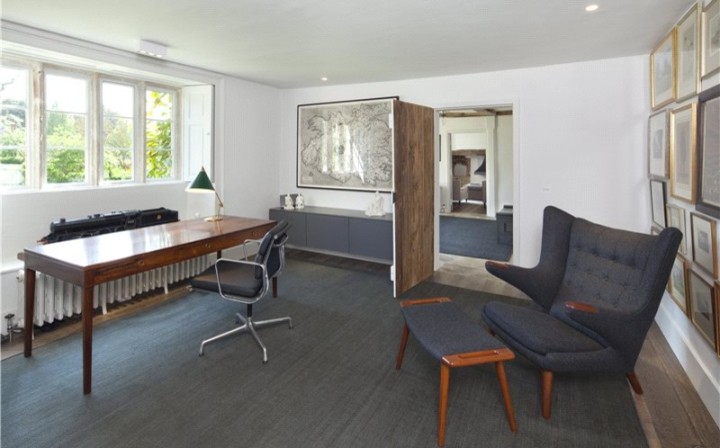 Diseño de despacho campestre grande sin chimenea con paredes blancas, suelo de madera oscura y escritorio independiente