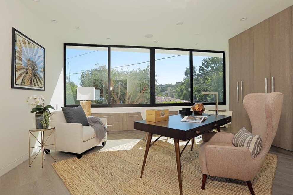 Medium sized contemporary home office in Los Angeles with white walls, medium hardwood flooring and a freestanding desk.