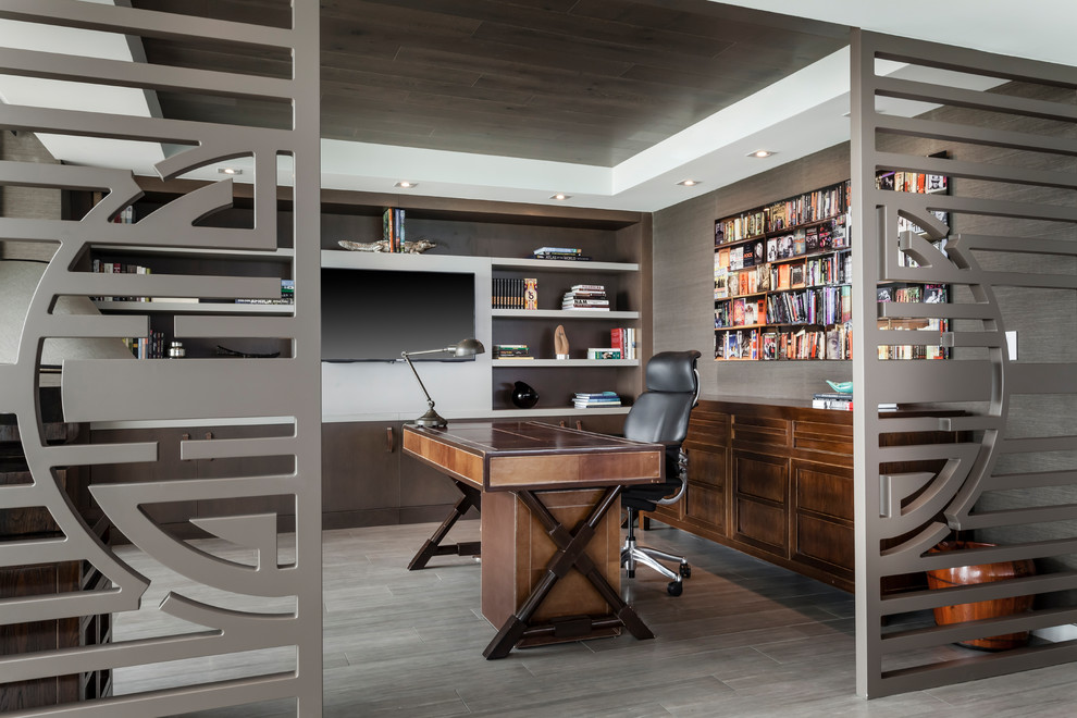 Пример оригинального дизайна: кабинет в современном стиле с серыми стенами, отдельно стоящим рабочим столом и серым полом