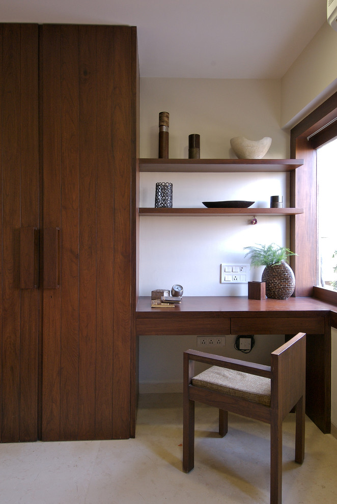 Пример оригинального дизайна: домашняя мастерская в современном стиле с белыми стенами, бетонным полом и встроенным рабочим столом