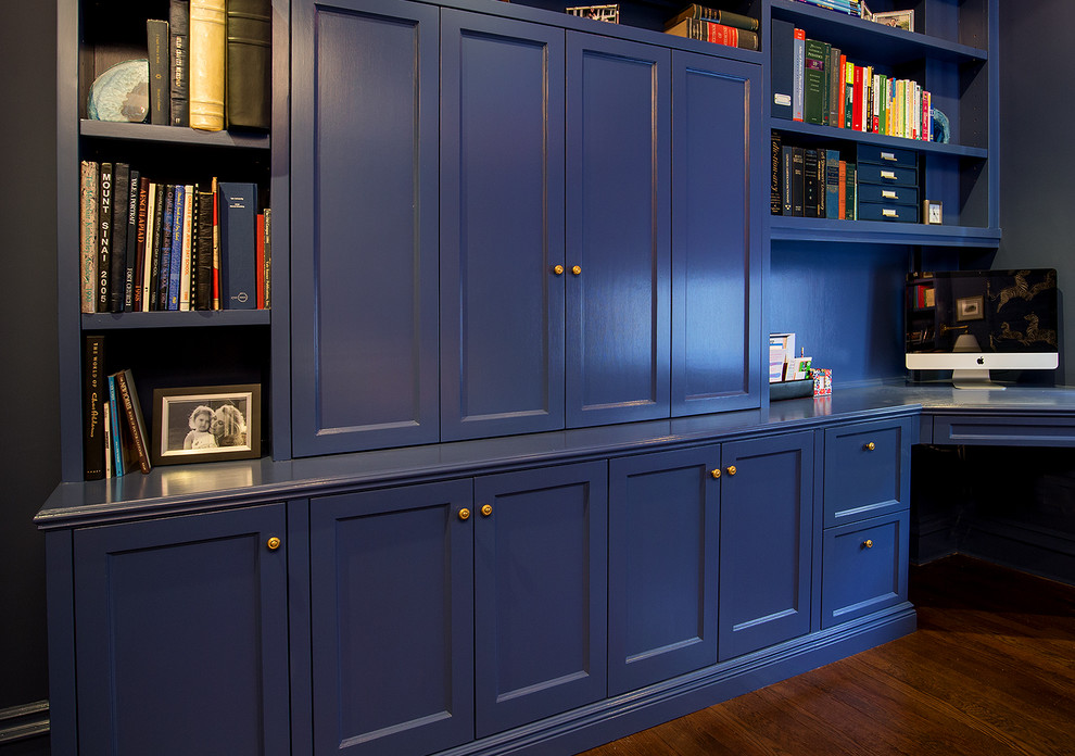 Cette photo montre un bureau tendance de taille moyenne avec un mur bleu, parquet foncé, aucune cheminée et un bureau intégré.
