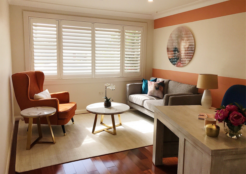 Idéer för ett litet modernt arbetsrum, med orange väggar, laminatgolv, ett fristående skrivbord och brunt golv