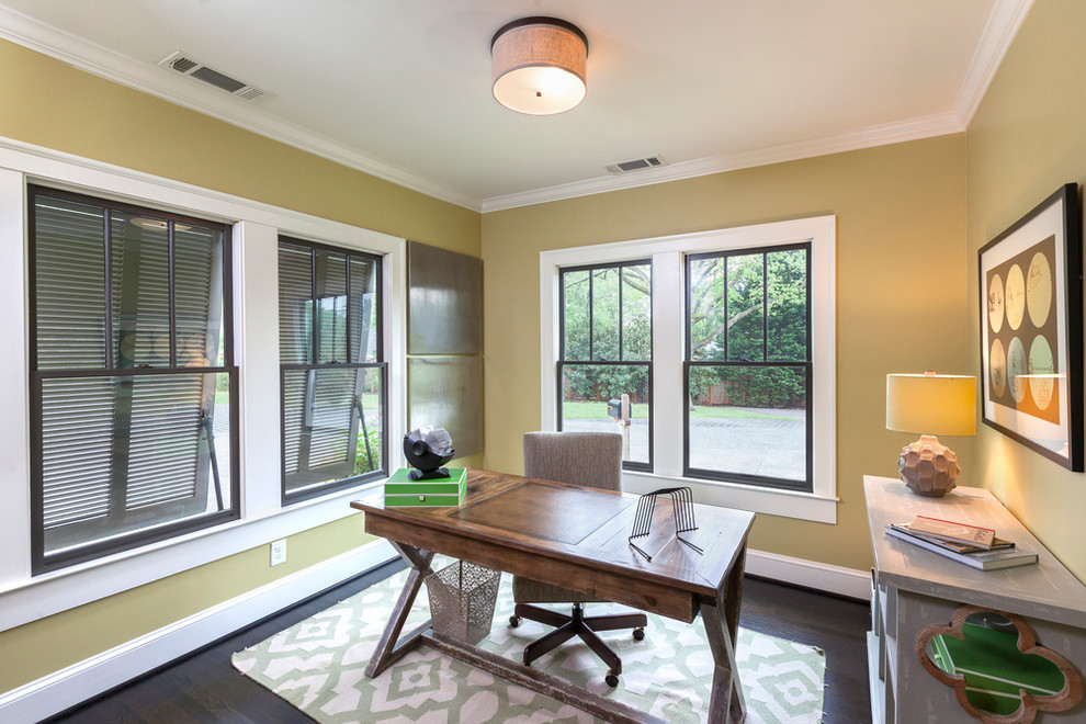 На фото: кабинет в современном стиле с желтыми стенами, отдельно стоящим рабочим столом и коричневым полом без камина с