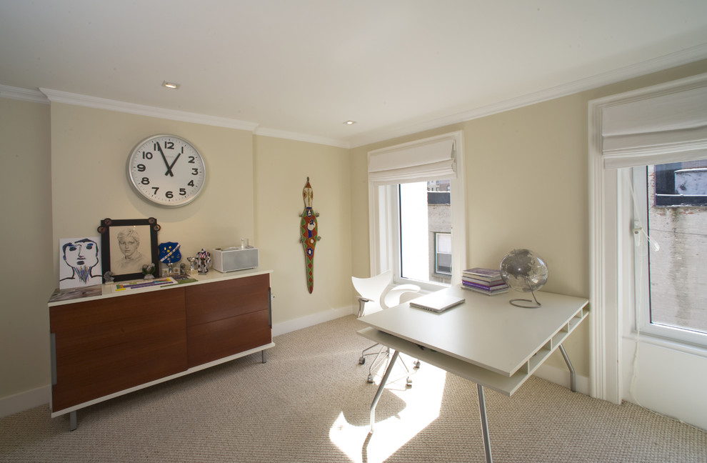 Immagine di uno studio minimal con pareti beige, moquette e scrivania autoportante