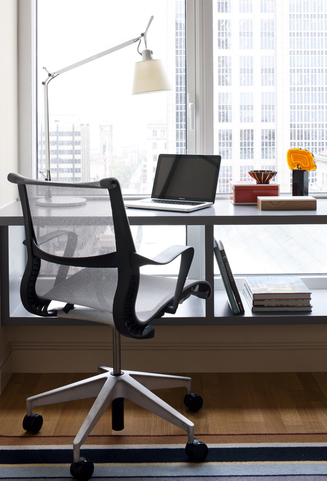 Imagen de despacho contemporáneo de tamaño medio con suelo de madera en tonos medios y escritorio independiente