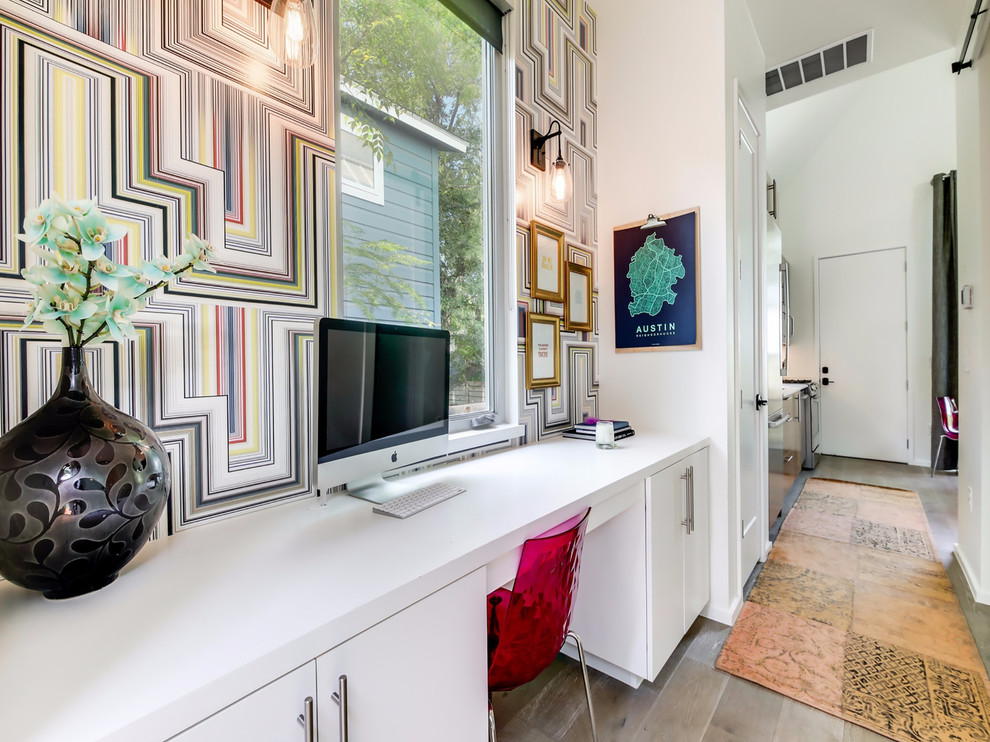 Cette image montre un bureau design avec un mur multicolore, un bureau intégré et un sol marron.