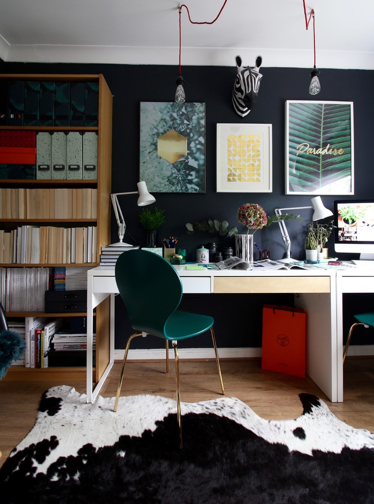 На фото: рабочее место в стиле фьюжн с отдельно стоящим рабочим столом, коричневым полом, черными стенами и паркетным полом среднего тона с
