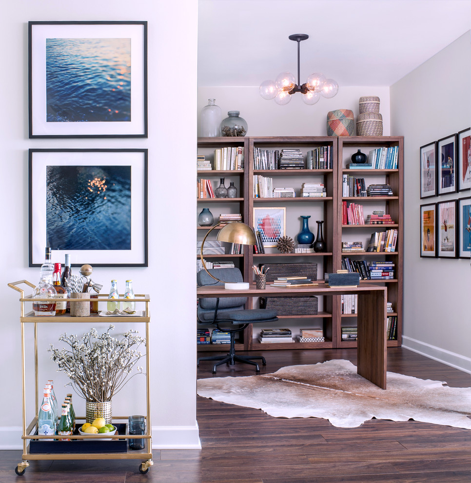 Example of a trendy freestanding desk medium tone wood floor study room design in Chicago with white walls