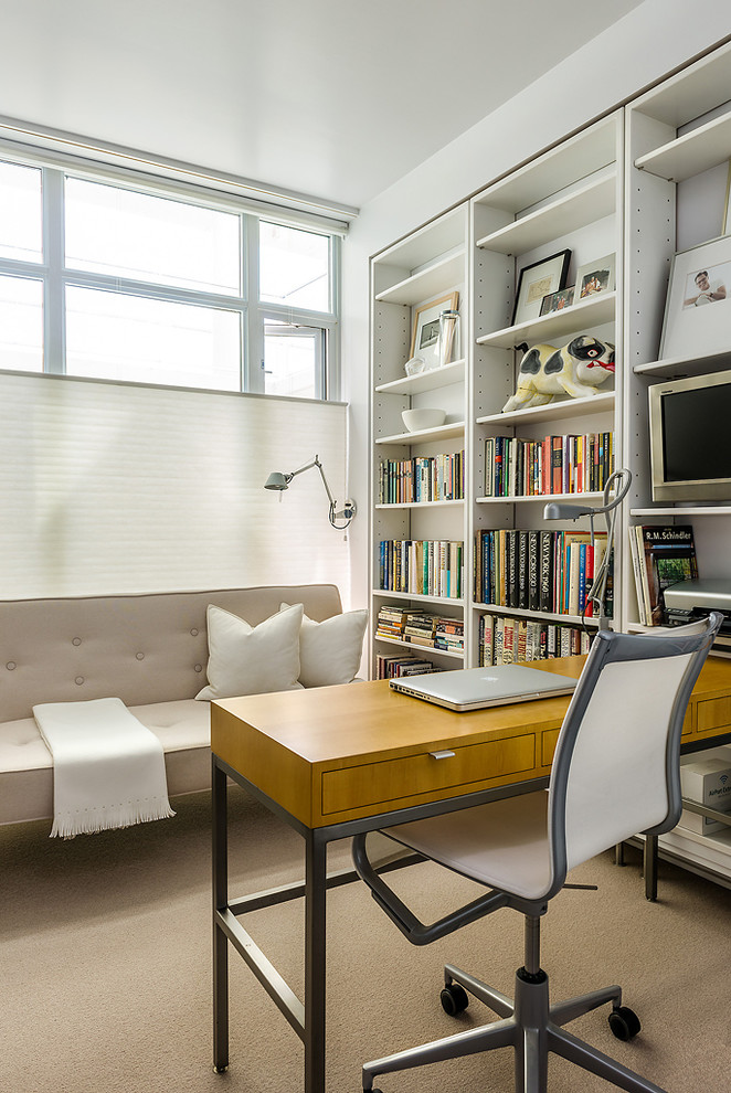 На фото: кабинет в современном стиле с белыми стенами, ковровым покрытием и встроенным рабочим столом с